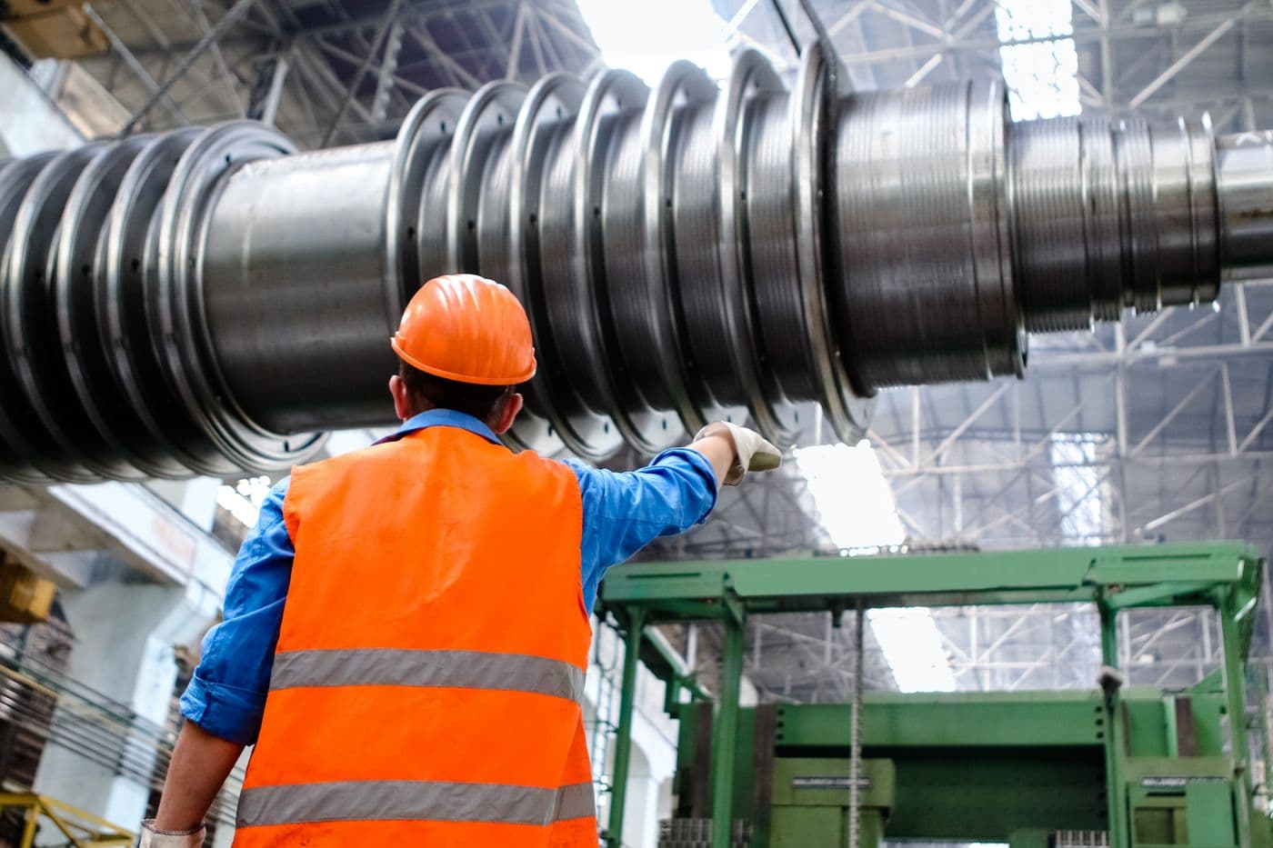 Engineer in hi-vis inspecting machinery in a factory
