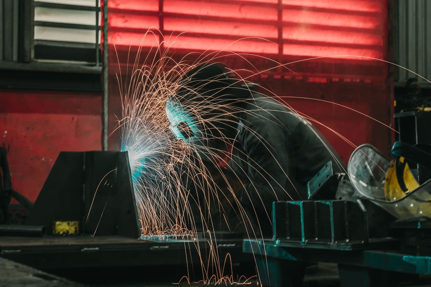 Welder fabricating steel in a workshop